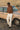 Man standing next to a vintage car in a desert-like setting