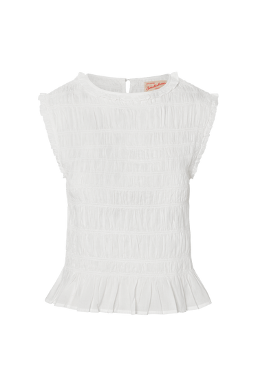 White sleeveless top with smocked design on a green background