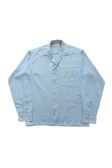 Light blue shirt with open collar on a white background