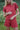 Woman wearing a red outfit standing in a natural setting
