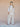 Woman wearing a beige outfit standing against a plain background