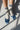 White socks with blue stripes and blue flats on a light gray surface