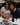 Two women sitting together with a table full of photos and stationery items in a room.