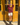 Woman wearing a merlot red knit sweater and cream knit shorts, standing in the sun outdoors.