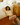 Woman in a yellow outfit set sitting on the floor next to a bed in a bedroom.