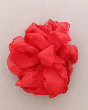 Red flower-like fabric item on a light gray background