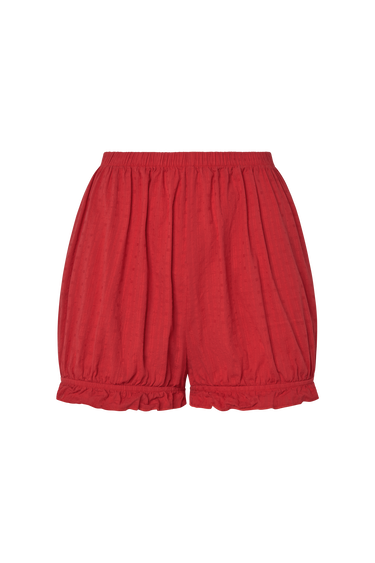 Red eyelet, bloomer-style shorts with ruffled hem on a white background.