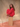 Woman sitting on a wooden block wearing a red, rolled hem sweater and matching red sweater pants.