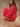 Woman sitting on a wooden block wearing a red, rolled hem sweater and matching red sweater pants.