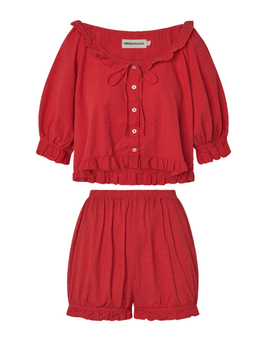 Red eyelet, button-up blouse with a ruffled neckline and matching bloomer-style shorts set on a white background.