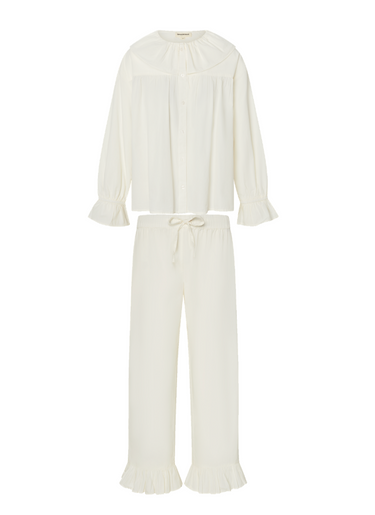 White long sleeve blouse with a ruffled collar and matching pants with a ruffled hem on a white background.