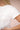 Person wearing a plain white t-shirt against a neutral background