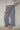 Woman wearing blue plaid casual pants with a ruffled ankle hem against a plain background.
