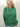 Person wearing a green cardigan against a neutral background