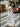 Woman in a white dress with black polka dots walking on a street.
