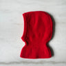 Red knitted balaclava on a light gray background