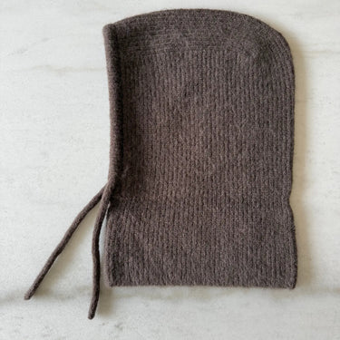 Brown knitted bonnet on a light gray background