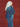 Person wearing a blue denim jacket and jeans against a red background