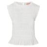White sleeveless top with smocked design on a green background