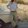 Woman standing next to a vintage car in a desert setting