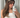 Woman taking a mirror photo of herself in a headband and white top.