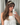 Woman taking a mirror photo of herself in a headband and white top.
