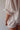 Close-up image of a woman wearing a white, bloomer-style shorts and a matching flowy, feminine top.