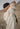 Person wearing a cream cable knit sweater in a desert setting