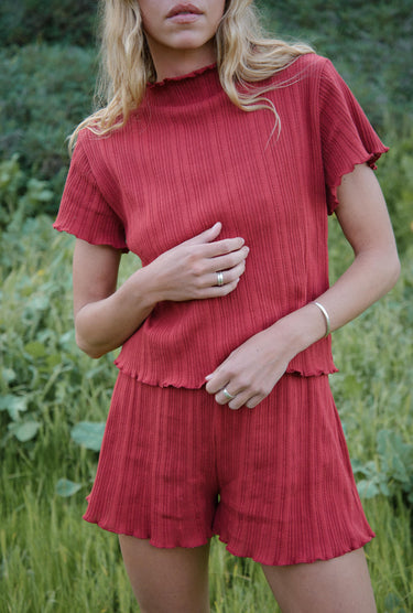 Woman wearing a red outfit standing in a natural setting