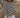 Woman standing in a field, wearing a black and white striped long-sleeved crewneck sweater with a white skirt.