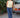 Woman in a yellow sleeveless top and blue casual pants standing next to a vintage Volvo car outdoors.