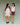 Two women wearing white tank tops and shorts on a plain background.