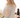 Close up image of a woman wearing a cream-colored crochet sweater while sitting on the back of horse.