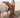 Woman in a brown outfit standing next to a white horse in a field.