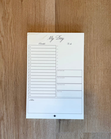 Notebook with a planner layout on a wooden surface