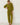 A woman wearing a matching olive green lounge set consisting of a long-sleeve top and relaxed pants, standing against a white wall.