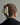 Person wearing a large matte cream hair clip on a plain background