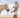 Woman feeding a horse in an open field with a clear sky