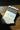 Striped sock with 'Le Bon Shoppe' label on a wooden surface