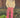 Woman wearing a cream, cable knit sweater and red gingham pants standing on a leaf-covered ground.
