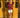 Woman wearing a merlot red knit sweater and cream knit shorts, standing in the sun outdoors.