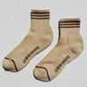 Beige socks with brown stripes and 'Le Bon Shoppe' branding on a light gray background