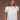 A woman wearing a vintage-inspired white blouse with short, billowy sleeves and a flowy bodice, detailed with delicate embroidery and lace.