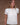 A woman wearing a vintage-inspired white blouse with short, billowy sleeves and a flowy bodice, detailed with delicate embroidery and lace.