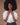 A woman wearing a white, vintage-inspired blouse with billowy sleeves and lace detailing on the yoke, tucked into dark pants.