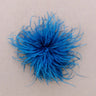 A bright blue feather pom-pom accessory on a plain beige background.