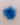 A bright blue feather pom-pom accessory on a plain beige background.
