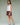 Woman wearing a white tank top and brown shorts on a green background.
