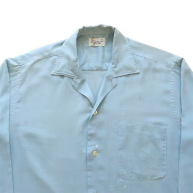 Light blue shirt with collar and pocket on a white background