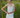 Woman standing in front of a field with long grass, wearing a pointelle tank top and white denim skirt.